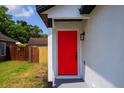 Close-up of a vibrant red front door with modern black hardware at 6856 Ebans Bend, Orlando, FL 32807