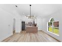 Open-concept kitchen with an island and modern chandelier at 6856 Ebans Bend, Orlando, FL 32807