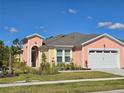 Eye-catching home featuring a colorful exterior with well-manicured landscaping under a bright blue sky at 726 Coral Reef Way, Daytona Beach, FL 32124