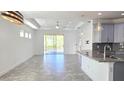 Open-concept living room featuring tile floors, recessed lighting, and a large sliding glass door to the backyard at 726 Coral Reef Way, Daytona Beach, FL 32124