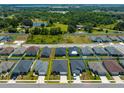 An aerial view showcasing the home's position within a quiet residential neighborhood surrounded by lush greenery at 871 Orleans Dr, Eagle Lake, FL 33839