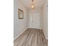 Inviting entryway featuring wood-look floors and a stylish light fixture above the front door at 871 Orleans Dr, Eagle Lake, FL 33839