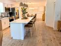 Bright, open kitchen featuring a large island with seating, stainless steel appliances, and modern light fixtures at 107 Hilltop Dr, Longwood, FL 32750