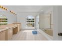 Well lit primary bathroom offers dual sinks, vanity space, tub and walk in shower at 1240 Falconcrest Blvd, Apopka, FL 32712