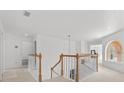 Bright hallway with staircase, white railings, and natural light, connecting the upper levels of the home at 1240 Falconcrest Blvd, Apopka, FL 32712