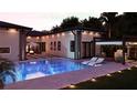 A serene backyard featuring a pool, sun loungers, an outdoor cooking area, and a cozy fire pit for entertaining at 12818 Brunello Cir, Clermont, FL 34711