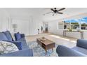 Bright living room with neutral tile, ceiling fan, and comfortable blue furniture at 1340 Bakersfield Ave, Deltona, FL 32725