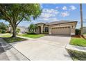 Charming single-story home featuring a large driveway and lush landscaping at 14003 Sobrado Dr, Orlando, FL 32837