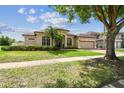 Inviting single-story home featuring lush landscaping and an attached two-car garage at 14003 Sobrado Dr, Orlando, FL 32837