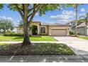 Charming single-story home with a well-manicured lawn and a mature shade tree in the front yard at 14003 Sobrado Dr, Orlando, FL 32837