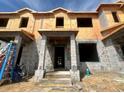 Unfinished townhome with block construction, prepped for finishes and featuring a covered entryway at 15345 Burgtheater Dr, Winter Garden, FL 34787