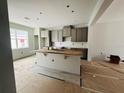 Spacious kitchen featuring gray cabinets, a large island, and white subway tile backsplash at 15345 Burgtheater Dr, Winter Garden, FL 34787