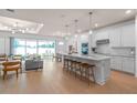 Modern, all-white kitchen with hardwood floors, stainless steel appliances, island, and pendant lighting at 1536 Groveline Rd, St Cloud, FL 34771