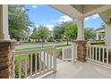 Covered porch with brick-based columns and white railing, offering a view of the quiet street at 15477 Blackbead St, Winter Garden, FL 34787