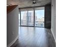 Spacious living area boasts large windows framing a vibrant cityscape and elegant wood flooring at 155 S Court Ave # 2406, Orlando, FL 32801