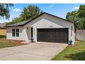 Charming single-story home featuring a two-car garage, fresh paint, and tidy landscaping at 1552 Whooping Dr, Groveland, FL 34736
