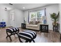 Cozy living area with a bright window, stylish furniture, and wood-look flooring at 1552 Whooping Dr, Groveland, FL 34736