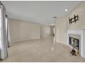 Bright living area featuring neutral tile, a fireplace, and ample natural light from the adjacent windows at 15628 Hidden Lake Cir, Clermont, FL 34711