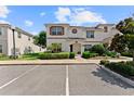 Well-manicured townhouse featuring clean white exterior, contrasted by brown trim and lush front yard landscaping at 1596 Moon Valley Dr, Davenport, FL 33896