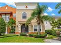 Inviting two-story townhouse featuring an arched entryway and lush tropical landscaping at 1745 Indiana Ave # J, Winter Park, FL 32789
