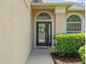 Close-up of front door with decorative wreath, sidelight and arched transom window at 2853 Strand Cir, Oviedo, FL 32765