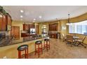 Spacious kitchen boasts granite countertops, cherry wood cabinets and an island with bar stool seating at 2921 Falconhill Dr, Apopka, FL 32712