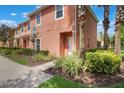 Charming townhome exterior showcases lush greenery and accessible pathway to the entrance at 3001 Red Ginger Rd, Kissimmee, FL 34747