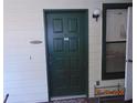 A green front door to unit 1007 with a shoe rack and a window at 3166 S Semoran Blvd # 1007, Orlando, FL 32822