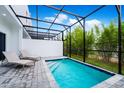 Private screened-in pool area with lounge chairs, pavers, and lush landscaping for a serene backyard oasis at 348 Famagusta Dr, Davenport, FL 33896