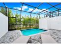 Inviting pool in screened enclosure, featuring stone pavers and comfortable lounge seating, perfect for outdoor relaxation at 348 Famagusta Dr, Davenport, FL 33896