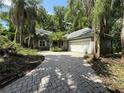 Charming home with a brick driveway and lush tropical landscaping surrounding the property at 4107 Gabriella Ln, Winter Park, FL 32792