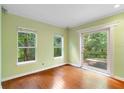 Bright room with hardwood floors, large windows, and sliding glass door leading to the backyard at 4107 Gabriella Ln, Winter Park, FL 32792