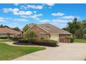Side view of a brick home showing the garage and driveway, surrounded by a manicured lawn at 441 Hightower Dr, Debary, FL 32713