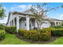 Inviting home with a covered porch, manicured landscaping, and a cozy rocking chair at 5013 E Fountainwood Dr, St Cloud, FL 34772