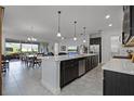 Open-concept kitchen featuring a large island, stainless steel appliances, and tile floors at 5013 E Fountainwood Dr, St Cloud, FL 34772