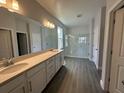 Primary bathroom with double sinks, quartz counters, and spacious walk-in shower with glass door at 5262 Teirgarten St, St Cloud, FL 34771