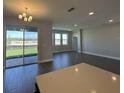 Bright open-plan living room features wood-look tile flooring and sliding glass doors to the outdoor living space at 5262 Teirgarten St, St Cloud, FL 34771