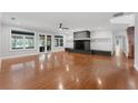 Spacious living room with hardwood floors, a stone fireplace, and natural light at 5655 Oak Hollow Ln, Oviedo, FL 32765