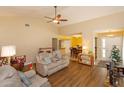 Cozy living room featuring wood floors, neutral paint, ceiling fan and open access to the dining area at 718 Wildwood Dr, Winter Springs, FL 32708