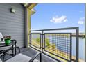 Balcony overlooking lake features metal railing, outdoor seating, and pleasant views at 7573 Laureate Blvd # 1-404, Orlando, FL 32827