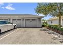 Attached garage with paved driveway, assigned parking spot, and well manicured landscape at 7573 Laureate Blvd # 1-404, Orlando, FL 32827