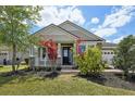 Inviting front porch with stone columns and a well-manicured lawn with colorful landscaping elements at 8420 Corkfield Ave, Orlando, FL 32832