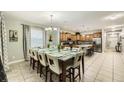 Open dining and kitchen area featuring stainless appliances, granite counters, and a large dining table at 8989 Cuban Palm Rd, Kissimmee, FL 34747