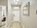 Entryway features neutral walls, tile flooring, a mirror, and view to the primary bedroom at 8989 Cuban Palm Rd, Kissimmee, FL 34747