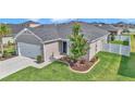 Charming front exterior of the home featuring a two-car garage, manicured lawn, and attractive landscaping at 9262 Sw 58Th Cir, Ocala, FL 34476