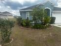 A view of a well-landscaped front yard featuring mature shrubbery at 1185 Sabine Ln, Kissimmee, FL 34759