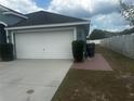 A view of the two-car garage with an attached driveway at 1185 Sabine Ln, Kissimmee, FL 34759