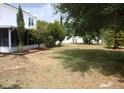 Backyard features mature trees, a well-manicured lawn, and the exterior of the house at 1009 Ronlin St, Haines City, FL 33844
