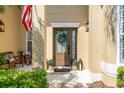 Inviting front door and covered porch with American flag, stylish lantern, and inviting welcome mat at 10160 Mallard Landings Way, Orlando, FL 32832