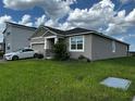 Beautiful home with a lush green lawn and two-car garage with a white car parked in the driveway at 1141 Lakeshore Breeze Pl, Kissimmee, FL 34747